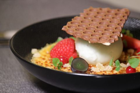 Dessert dressé sur assiette noire : crème brûlée, sorbet et gaufrette au chocolat