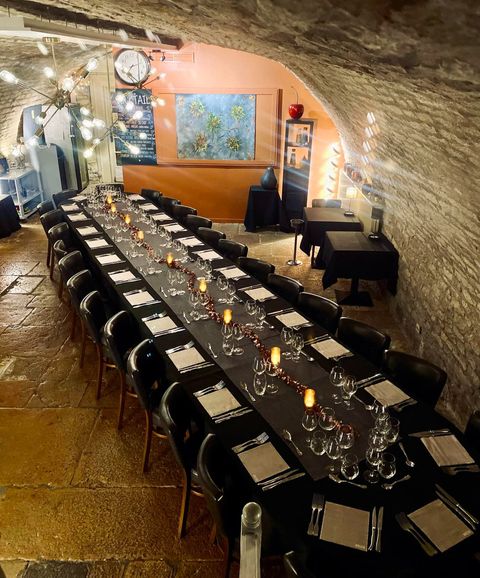 La cave voûtée en pierre du restaurant, dressée pour un repas de groupe